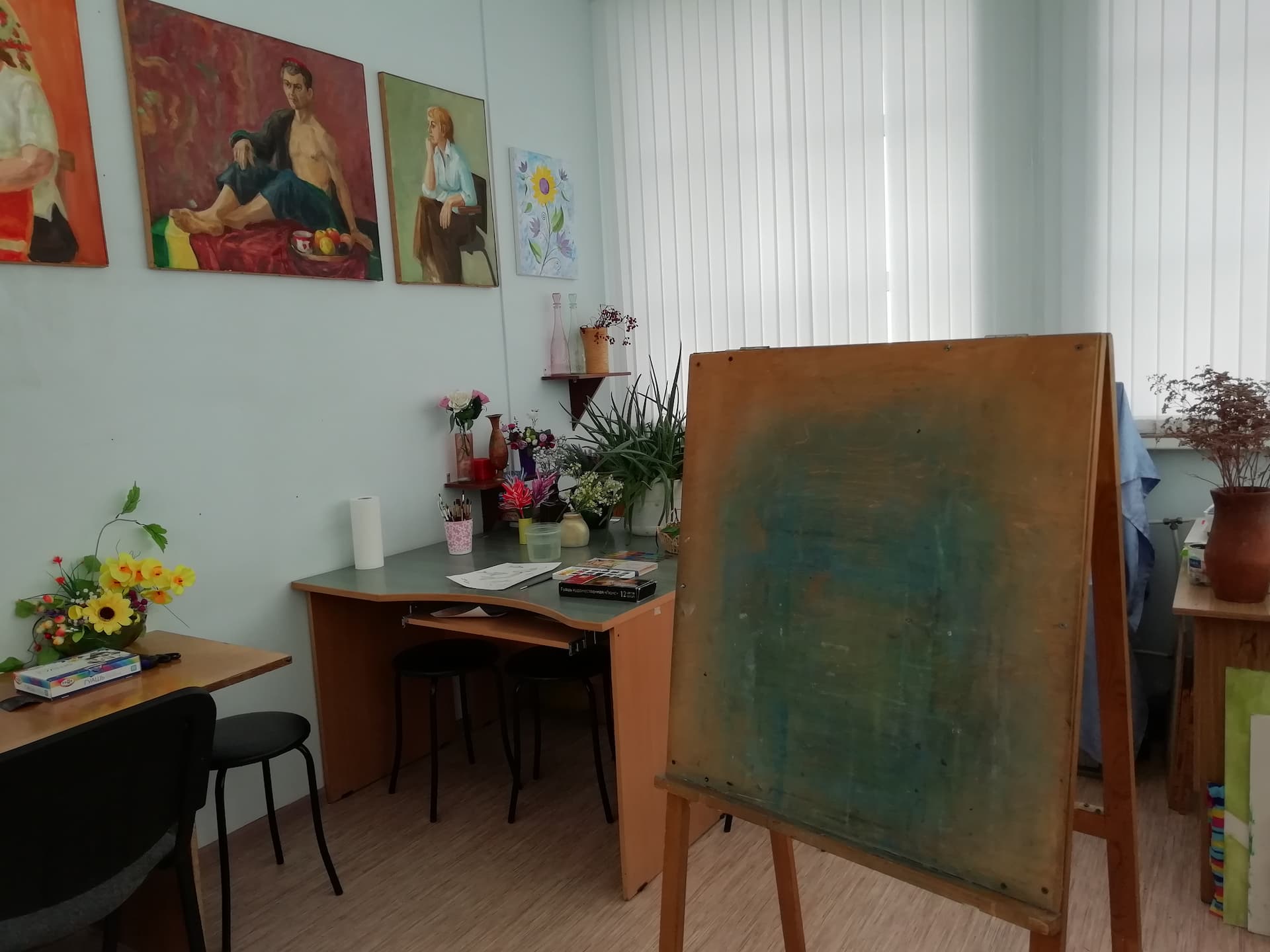 Интерьер арт-студии Палитра — мольберты, тёплый свет, холсты
