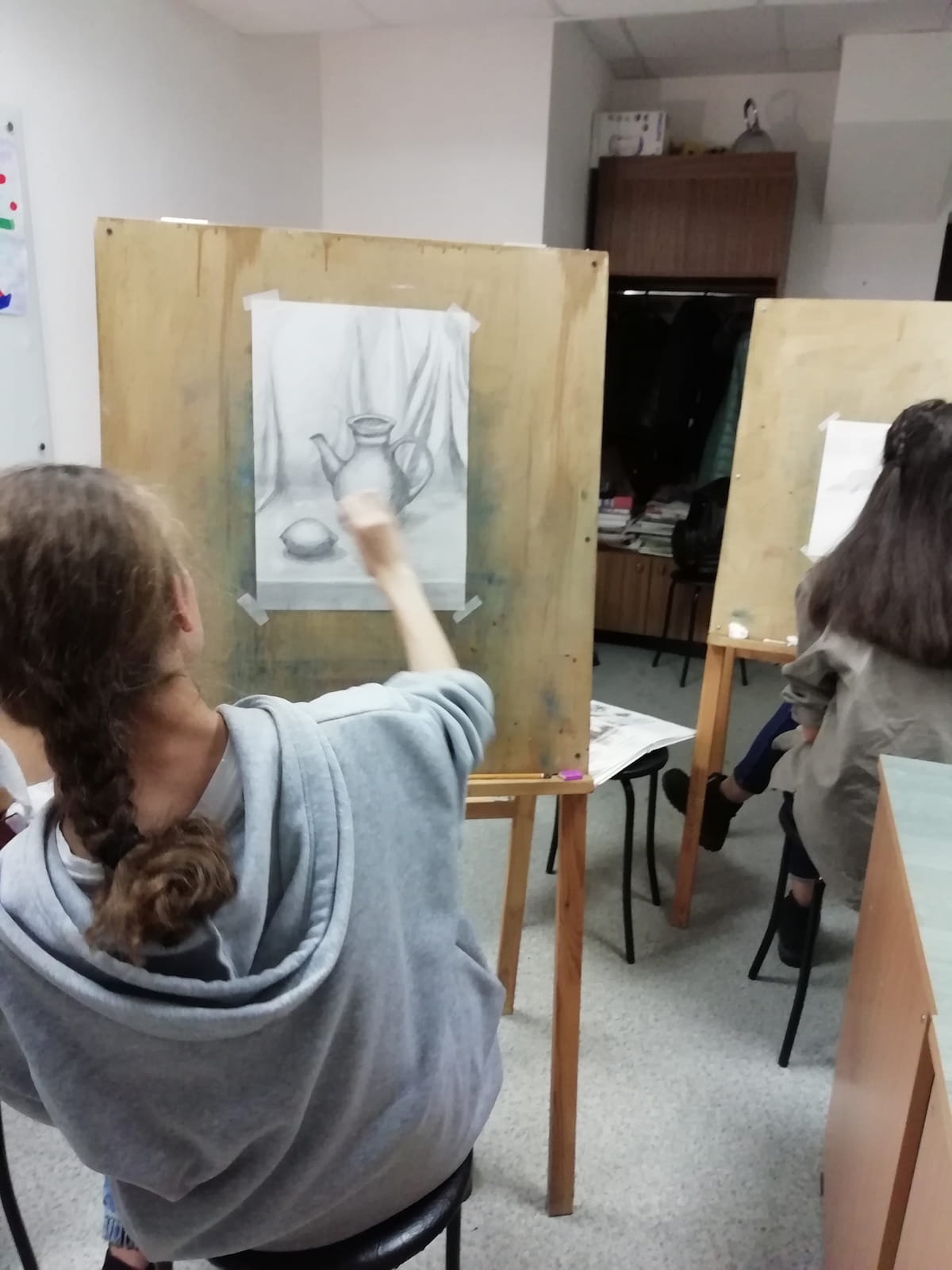 Подросток рисует за мольбертом